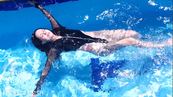 Latex-clad Jessica Bunny, Slick And Dripping, Curves Teased Beneath The Water